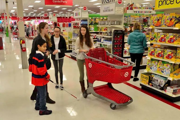 Thomas Burns, 9, gets assistance with his Christmas shopping in Target from Haddonfield Memorial High School students (left to right) Kelly Steltz, 15, Hannah Huff, 14, and Danielle Batterman, 16, on Sunday, December 7, 2014.  C.F. Sanchez / Staff Photographer