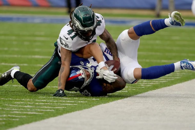 Eagles’ defensive back Ronald Darby, left, tackles the Giants’ Evan Engram, right, in the first quarter of the Eagles 34-29 win.