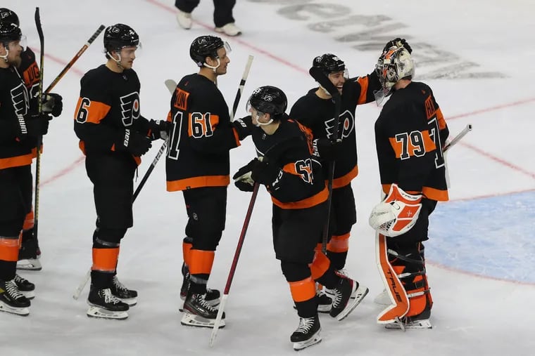 Goalie Carter Hart, right, is congratulated by Ivan Provorov and other Flyers teammates after his shutout against the Coyotes at the Wells Fargo Center on Nov. 2, 2021.