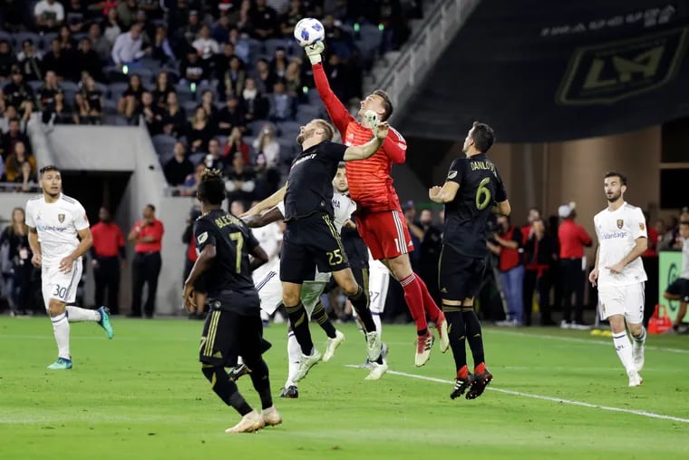 Los Angeles FC goalkeeper Tyler Miller (1) punches the ball next to Real Salt Lake's Danilo Acosta (25) during the second half of an MLS soccer playoff match Thursday, Nov. 1, 2018, in Los Angeles. Real Salt Lake won 3-2. (AP Photo/Marcio Jose Sanchez)