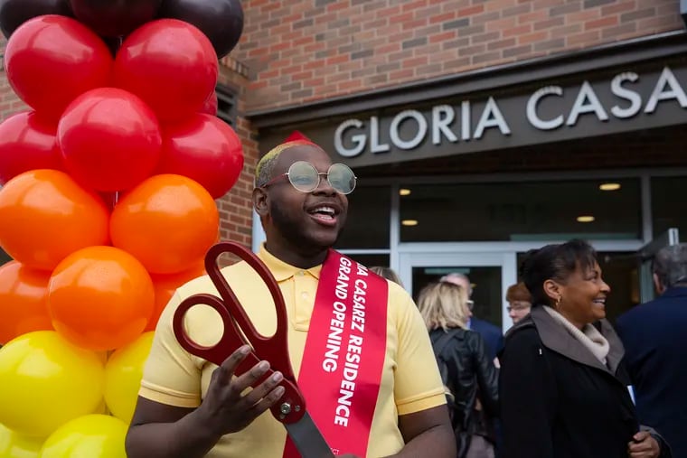 James Allen,20, who has experienced homelessness, holds a scissors after the ribbon cutting and grand opening celebration for the Gloria Casarez Residence on Tuesday.The building of 30 apartments is the first residence in Pennsylvania to provide permanent housing for young adults that is LGBTQ-friendly