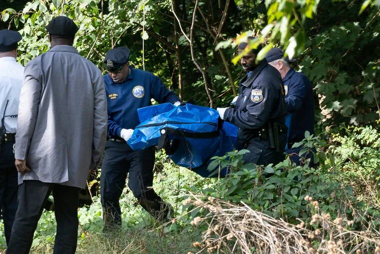 Police remove the body of a 1-year-old girl found buried Kemble Park in Ogontz.