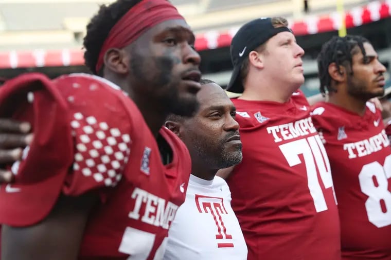 Temple head coach Stan Drayton stands arm-in-arm with his team after the Owls' home game against Rutgers at Lincoln Financial Field.