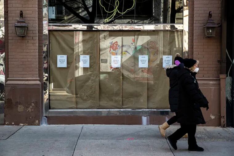 Signs reading "Vacant. Nothing of any value onsite" hang in empty retail space near South 19th and Sansom Streets in Philadelphia on Sunday.