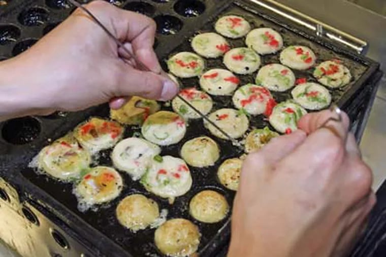 Takoyaki balls - which are Japanese street food - are prepared at Maru Global, 255 S. 10th St. The balls are the restaurant's specialty. (Steven M. Falk / Staff Photographer)