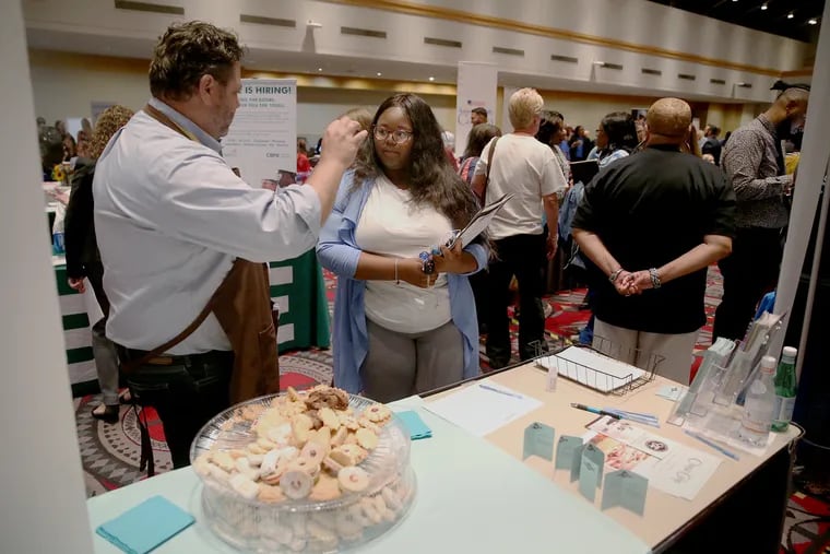 Jarrett Kratchman, left, chief financial officer off Classic Cake, talks with Kianna Veal, a former medical assistant student, during a "Hire Hahnemann" job fair at the Pennsylvania Convention Center in Philadelphia in 2019. Employers in the city may no longer ask job applicants their salary history as part of an ordinance aimed to cut the wage gap for women and people of color.