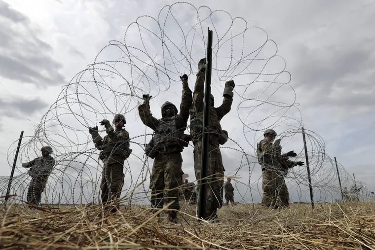 Members of a U.S Army engineering brigade place concertina wire around an encampment for troops, and personnel from the Department of Defense and U.S. Customs and Border Protection near the U.S.-Mexico International bridge, Sunday, Nov. 4, 2018, in Donna, Texas.