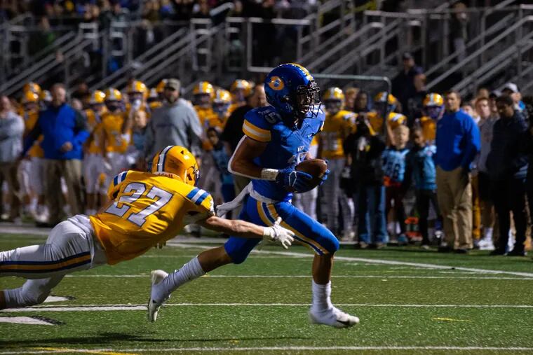 Downingtown West's Tyriq Lewis (No. 15), eludes Downingtown East's Cannon Lucas-Murphy (No. 27) en route to one of his four touchdowns in the Whippets' 63-35 victory.