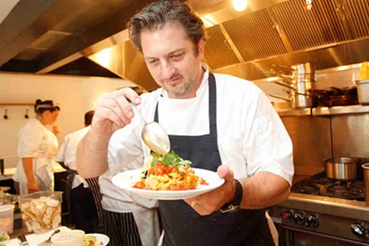 At a. kitchen, chef Bryan Sikora adds some salsa to a plate of chorizo frittata. (Charles Fox / Staff Photographer)