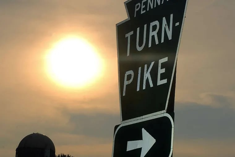 Sun comes up on Pennsylvania Turnpike sign.  (Tom Gralish / Inquirer)
