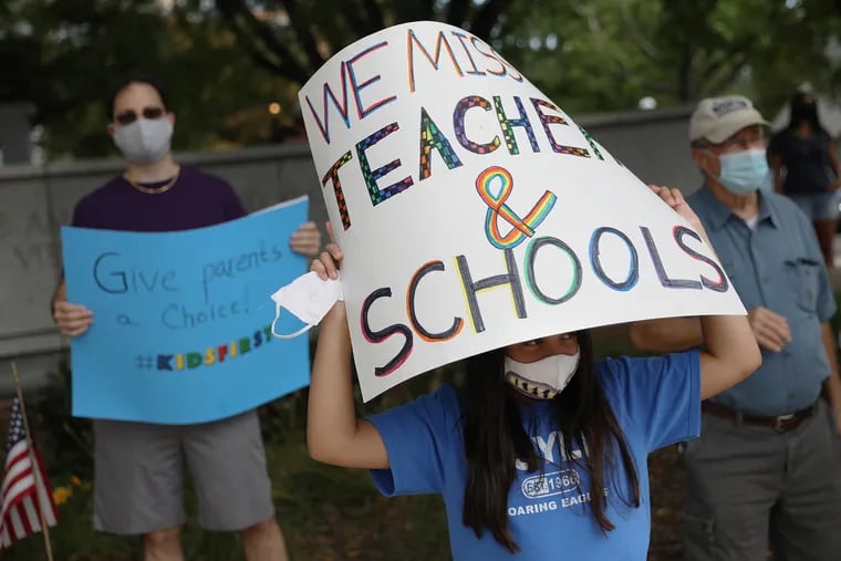 Vanessa Martino, 11, a student at Doyle Elementary School, holds a sign during a protest calling for the Central Bucks School District to offer in-person classes in downtown Doylestown, Pa., on Saturday, Aug. 15, 2020. The district said Aug. 10 that it would begin the school year virtually, citing staffing shortages, but some parents and students want to have the option of in-person classes.