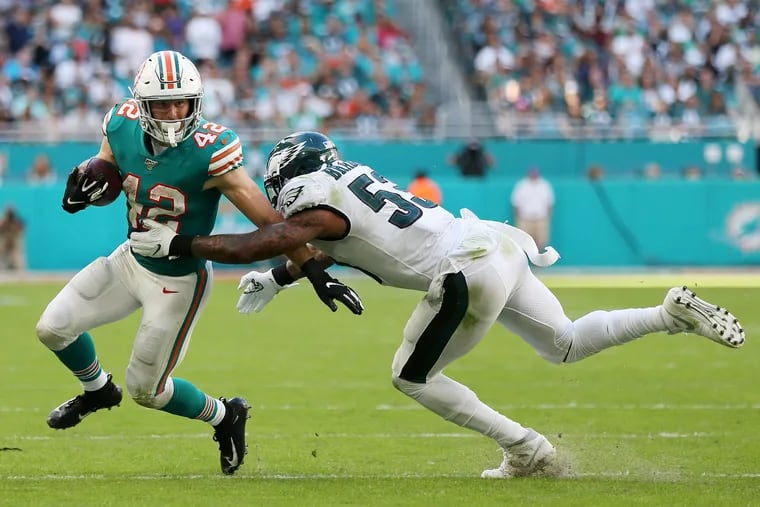 Miami Dolphins running back Patrick Laird (42) breaks a tackle attempt by Eagles linebacker Nigel Bradham (53) during Sunday's game.