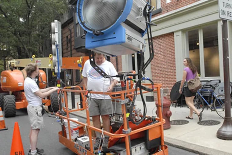 The filming transforms life on 20th Street between Locust and Spruce — a lighting setup took a corner. (April Saul / Staff Photographer)