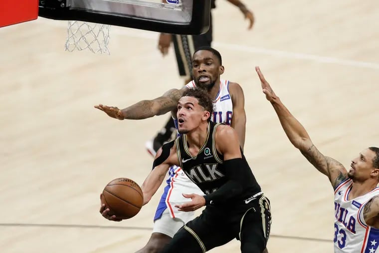 Atlanta's Trae Young drives to the basket against the Sixers' Shake Milton and George Hill during the third quarter of Game 4