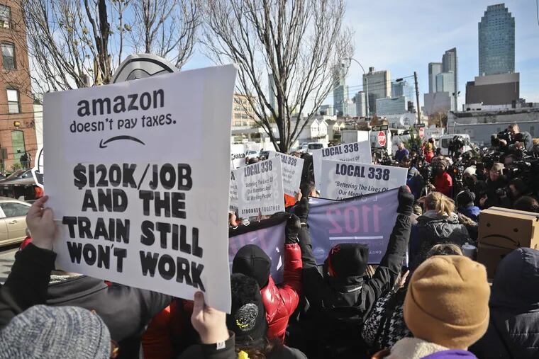 Protesters carry anti-Amazon posters during a rally opposing Amazon headquarters getting subsidies to locate in the New York neighborhood of Long Island City, Queens.