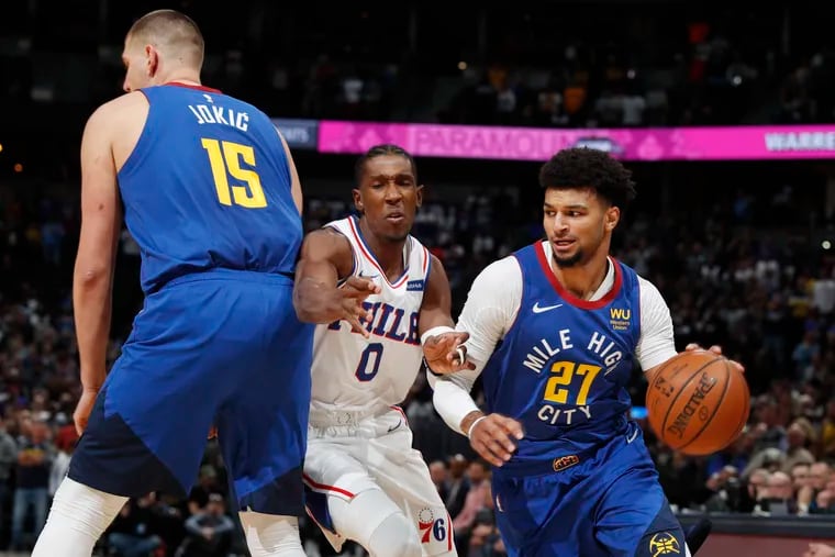 Sixers guard Josh Richardson (center) is hit as he tries to slip past a pick set by Denver center Nikola Jokic (left), allowing guard Jamal Murray to drive to the rim in the first half of the Nuggets' 100-97 win Friday night.