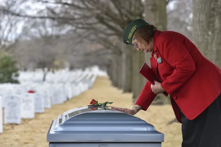 Eileen Skahill, national chaplain of the Women Marines Association, places her hand on the casket of retired Marine Master Sgt. Catherine G. Murray.