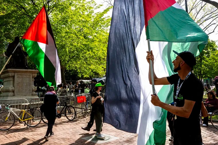 Protesters wave large Palestine flags at the tent encampment protest at the University of Pennsylvania Sunday. Protests are continuing for a fifth straight day.
