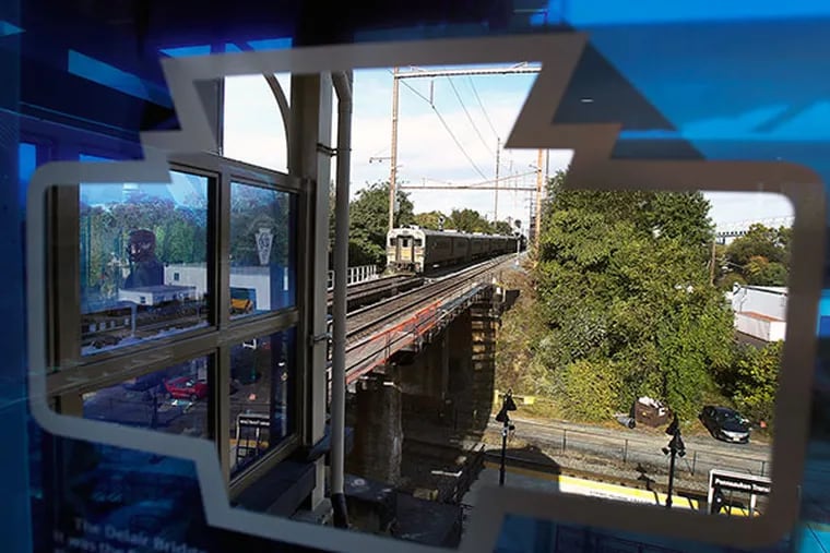 A New Jersey Transit train bound for Philadelphia leaves the transportation center in Pennsauken, seen through a station window. The financially troubled agency plans to raise fares 15% beginning July 1, 2024.