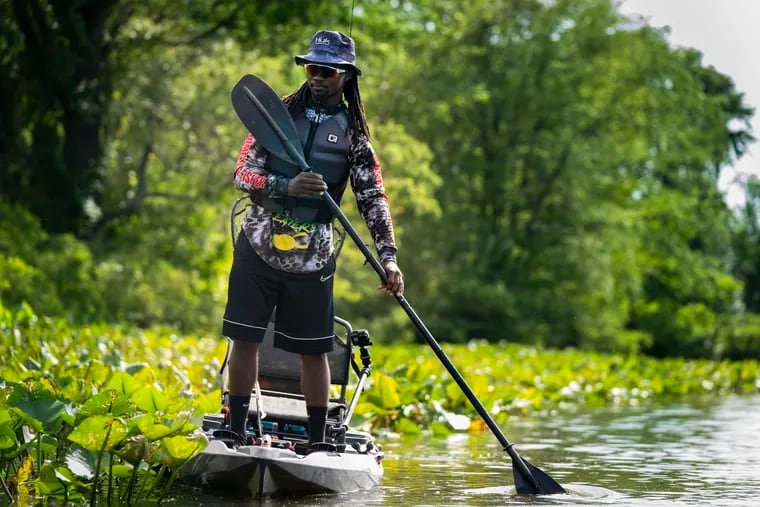Neaven Reevey, 26, of Camden, takes his kayak out on Newton Lake in Collingswood to fish for snakeheads, which live in shallow, vegetation-choked areas.