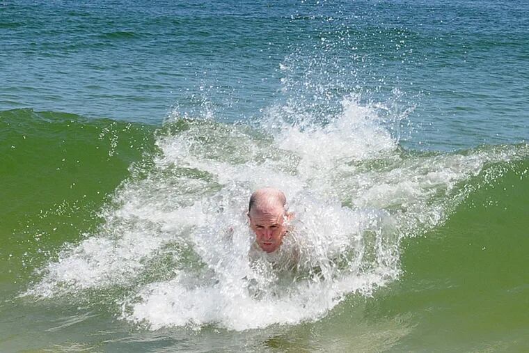 Doug Maday, of Island Heights, rides a wave during his daily swim on the Grant Avenue Beach in Seaside Park. ( DAVE GRIFFIN / For The Inquirer )