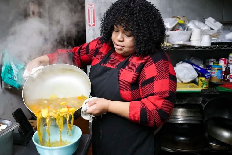 Marline Idopcil transfers Soup Joumou to a bowl inside her kitchen at Food Fusion Cuisine in Northeast Philadelphia.