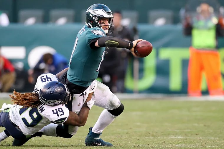 Eagles quarterback Carson Wentz tosses the ball to Eagles’ Miles Sanders, not pictured as Seattle Seahawks outside linebacker Shaquem Griffin, left, tries to bring him down in the 4th quarter. Philadelphia Eagles fall 17-9 to the Seattle Seahawks at Lincoln Financial Field in Philadelphia, PA on November 24, 2019.