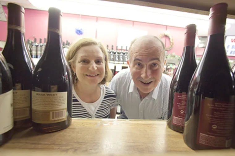 Owners Mario and Ann Del Monte look at open shelving that had been filled with wine before hurricane rush at Kress Wines in Cherry Hill on Tuesday. (David M Warren / Staff Photographer)