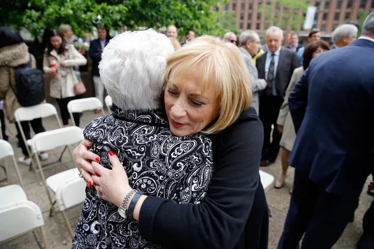Mim Kirk (right), president of the Children of Jewish Holocaust Survivors Association of Philadelphia, hugs Miriam Cane, vice president of the Holocaust Survivors Association of Philadelphia, during the announcement and ceremonies.