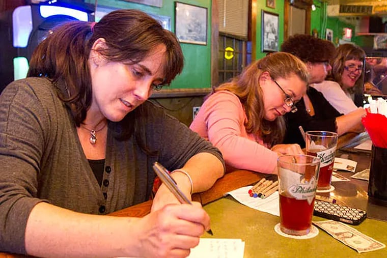 At a Publetters event at Paddy's Pub, Tara McCray (left) and Melody Jones put pen to paper and write letters. (CHARLES FOX / Staff Photographer)
