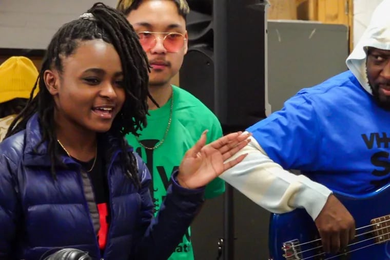 Wyclef Jean plays music with sophomore Suhaylah Brown, 16, from South Philadelphia High School after announcing that the school will receive $50,000 to upgrade music technology.