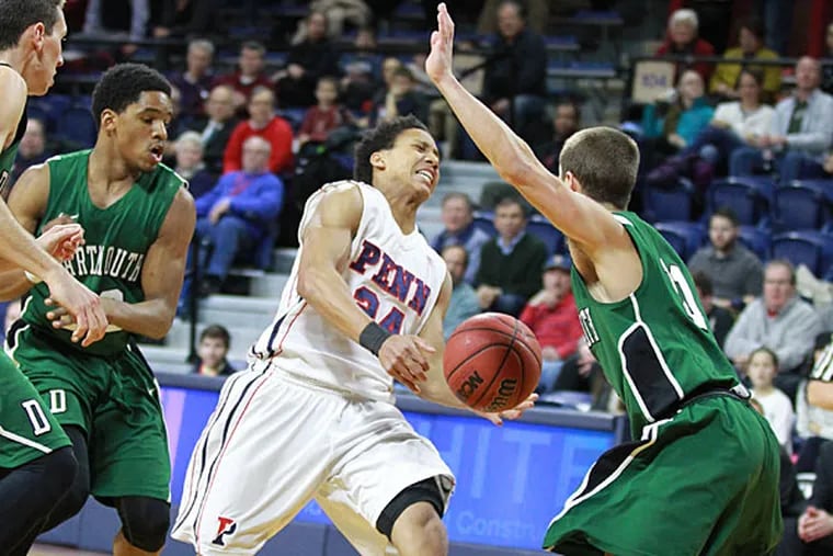 Matt Howard, center, of Penn loses the ball as he tries to drive
between Dartmouth defenders in the 1st half on Jan. 30, 2015.  (Charles Fox/Staff Photographer)