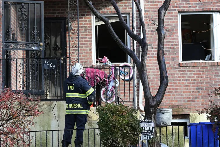 A fire marshal examines the scene of a fire at 1005 Medary Ave. in Philadelphia on Tuesday, Dec. 22.