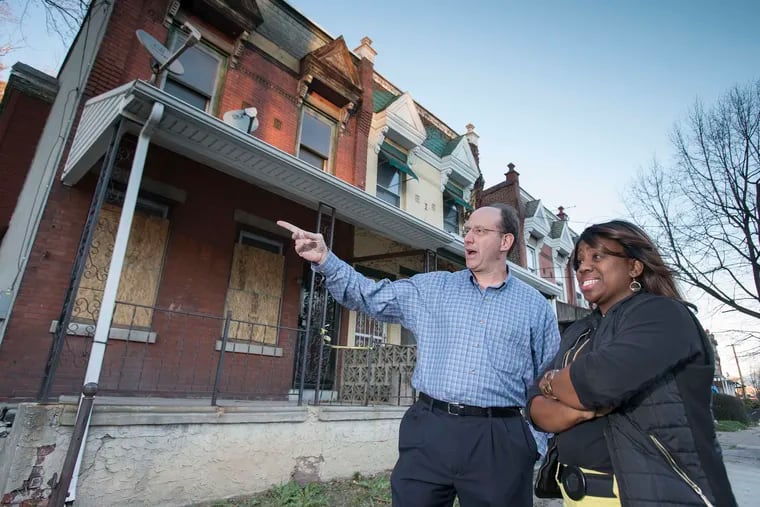 In this 2015 photo, Ken Weinstein, founder of the Jumpstart program, which gives loans and support to aspiring real estate developers, talks with Donna Tiffany Tull, one of the earliest participants in the program, on Belfield Avenue in Philadelphia's Germantown neighborhood.