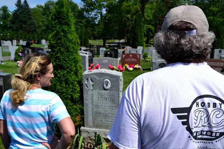 Inna Devinsky and Aleksey Lomov stand in anger in front of Lomov's father's grave that was damaged by the grounds crew of Shalom Memorial Park on Wednesday, June 18, 2014.