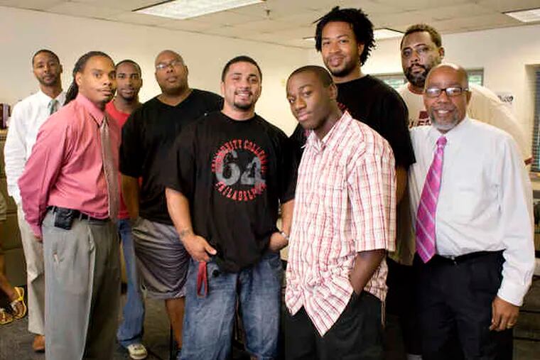 Michael Robinson (right), director, with students and staff members at the Center for Male Engagement of the Community College of Philadelphia. With a federal grant, the year-old center provides services meant to keep black males in college and see them graduate.