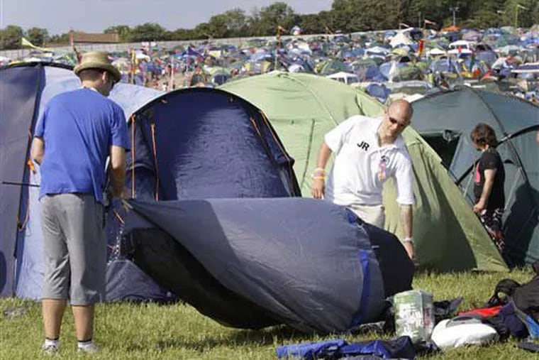 Glastonbury festival goers erect their tent on arrival at the Glastonbury Festival, Wednesday, June 23, 2010. The music festival celebrates its 40th anniversary this year. (AP Photo/Joel Ryan)