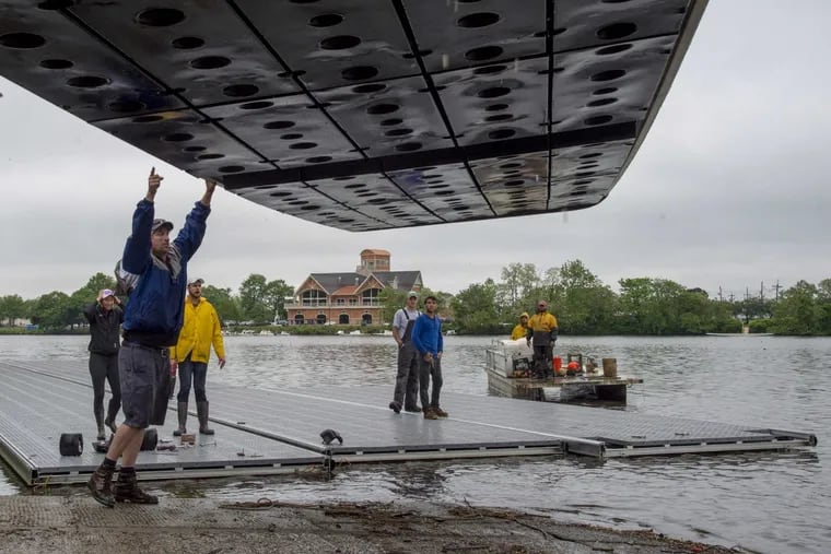 Workers unload docks into the Cooper River after transporting them from the Schuylkill on Wednesday. The Stotesbury Cup Regatta, the largest high school rowing regatta in the world, was forced by river  conditions to move from Philadelphia to New Jersey.