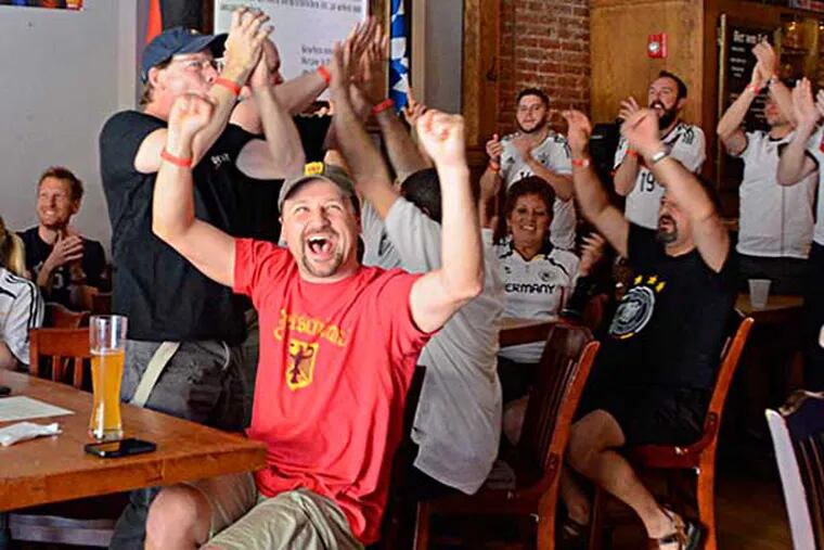 Dan Zulker (center) celebrating Germany's win over Portugal at Brauhas Schmitz. (VIVIANA PERNOT/Staff Photographer)
