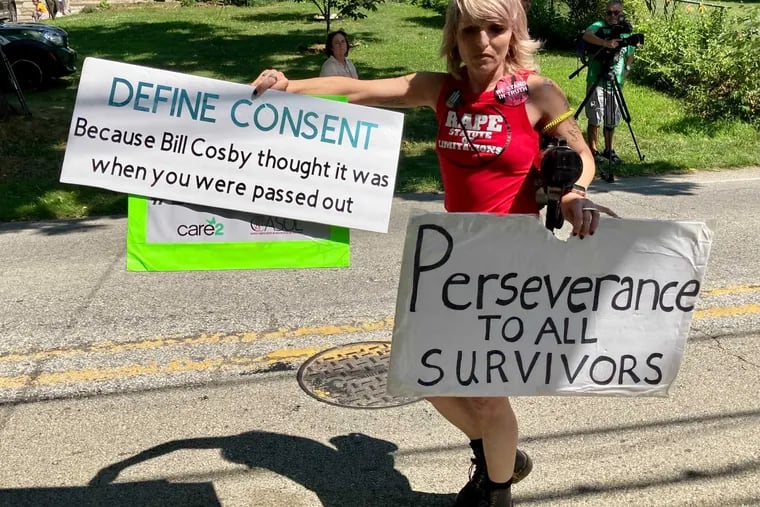 A protester stands outside Bill Cosby’s Elkins Park estate after the actor and comedian was released from prison Wednesday, June 30, 2021.