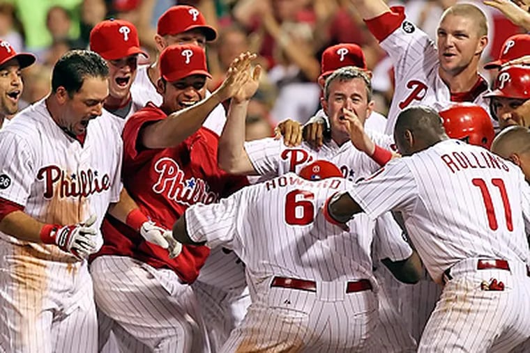 Ryan Howard is congratulated at the plate after hitting a walk-off home run. (Steven M. Falk / Staff Photographer)