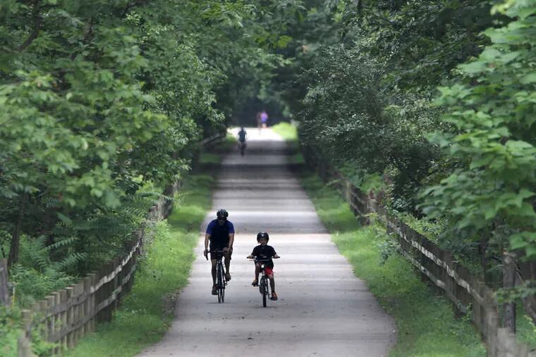 CHARLES FOX / STAFF PHOTOGRAPHER Two riders bike on the Schuylkill River Trail in Oaks, Montgomery County.