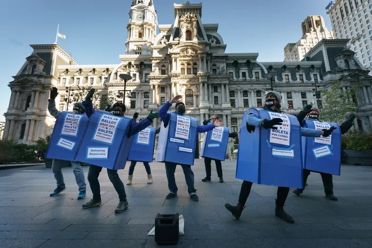 Performers from Delivering Democracy dressed as ballot boxes perform at City Hall in 2020.