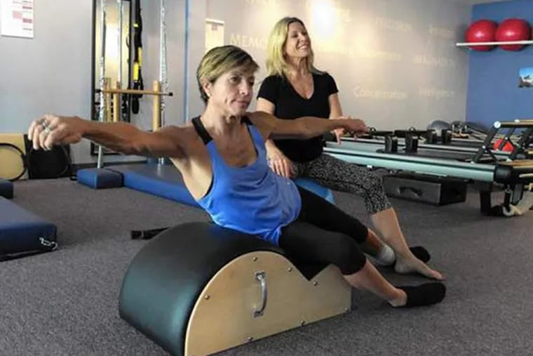 Delyn VanDyke, 52, who was hurt in a motorcycle crash in 2012, works to strengthen her body with trainer Tina Stathis, 48, at Tru Pilates and Yoga Studio in Altamonte Springs, Fla. Stathis is the owner. (Susan Jacobson/Orlando Sentinel/TNS)