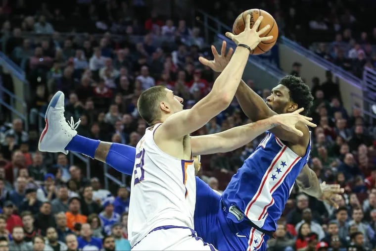 Sixers' Joel Embiid tries for the rebound wih Suns'Alex Len during the 1st quarter at the Wells Fargo Center in Philadelphia, Monday, December 4, 2017. STEVEN M. FALK / Staff Photographer