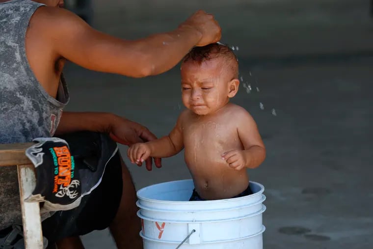 A migrant baby is given a bath at the AMAR migrant shelter in Nuevo Laredo, Mexico, Tuesday, July 16, 2019. A U.S. policy to make asylum seekers wait in Mexico while their cases wind through clogged U.S. immigration courts has also expanded to the violent city of Nuevo Laredo.