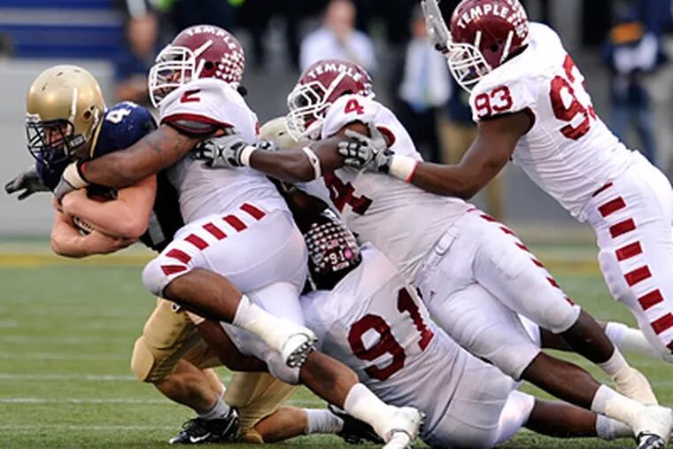 Navy's Vince Murray is brought down by a host of Temple defenders during the Owls'  27-24 win. (AP Photo/Gail Burton)