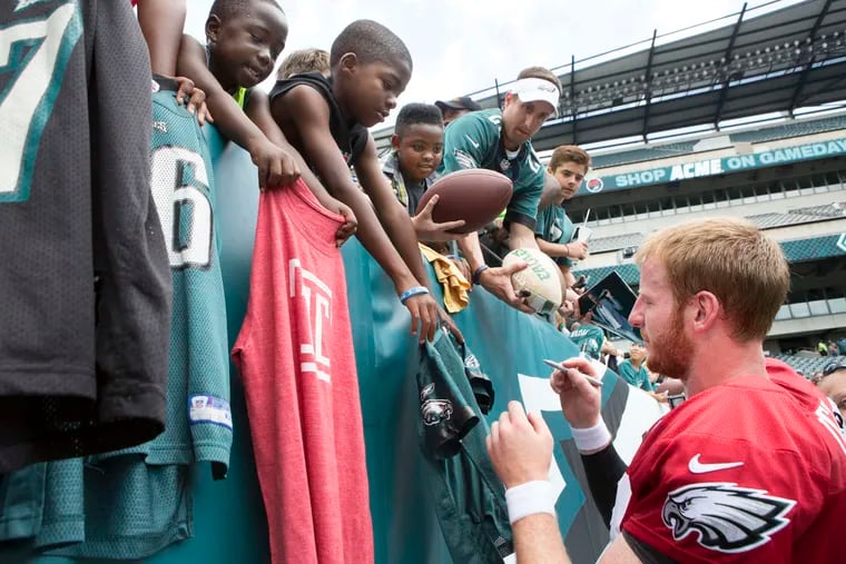 Eagles quarterback Carson Wentz signs autographs after the team's 2018 open practice at Lincoln Financial Field. This year, the Eagles will hold just one open practice at the Linc, which will cost fans $10 per ticket.