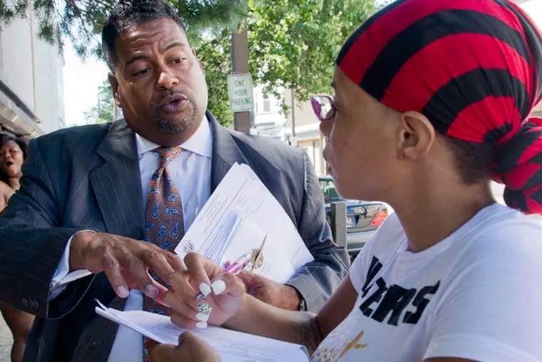 Gregory Shannon, the Chester Upland Schools superintendent, explains an enrollment form to Chantel Maultsby as part of his campaign in 2014. Shannon announced his resignation as superintendent Wednesday.