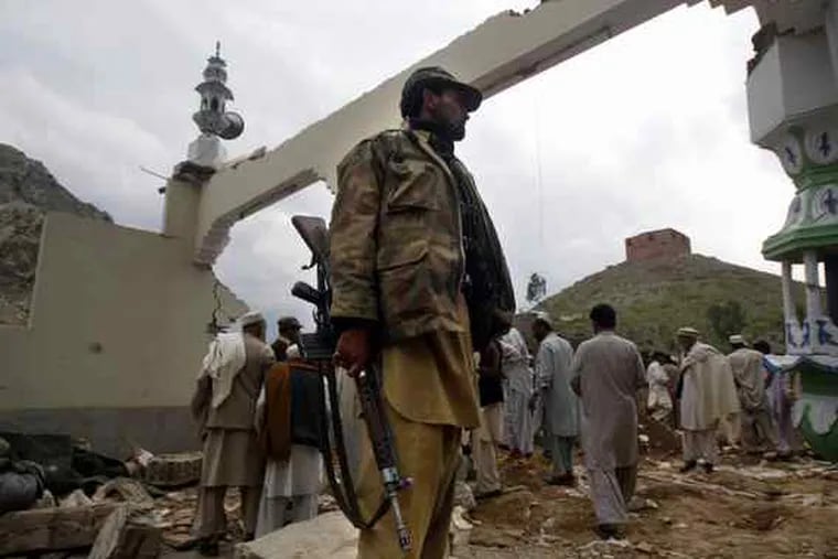The mosque's ruins frame a security officer after the blast. The bomber struck as worshipers packed the mosque.